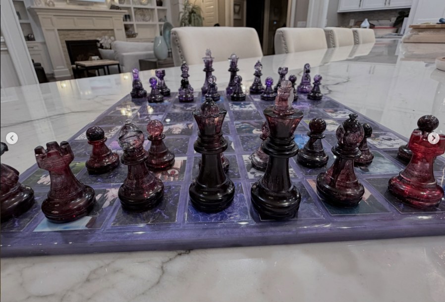 Handcrafted garnet and amethyst resin chess set on a marble table