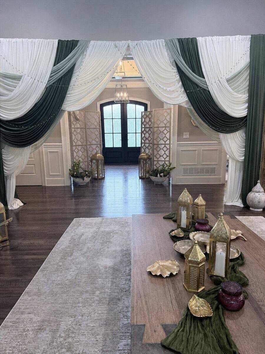 Draped entry archway in ivory and olive fabric with gold lanterns