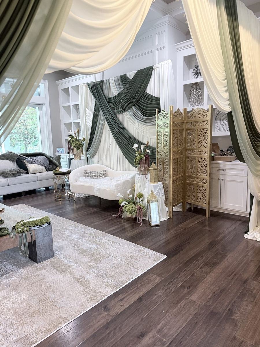 Event lounge dressed in white and olive ceiling drapery with styled seating