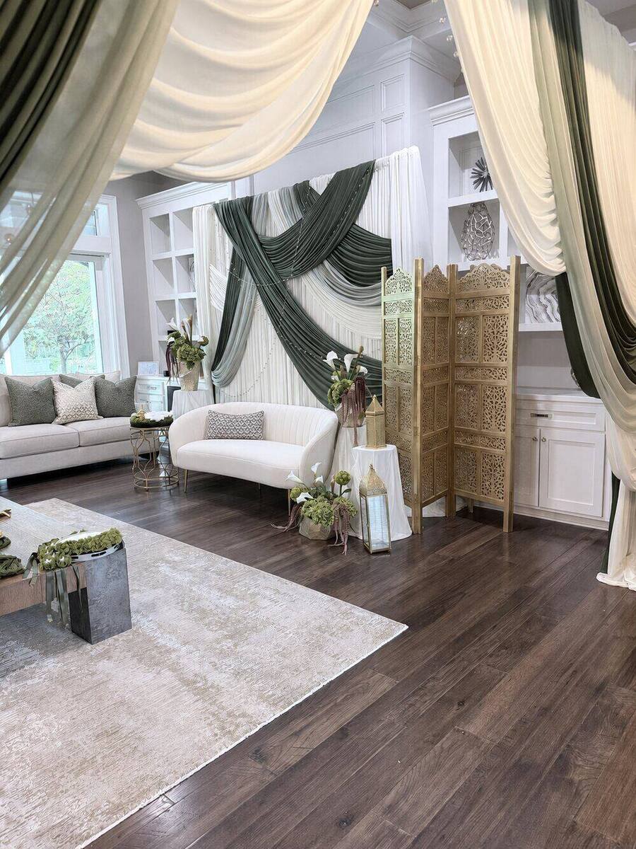 Lounge dressed in ivory and olive drapery with carved gold screens