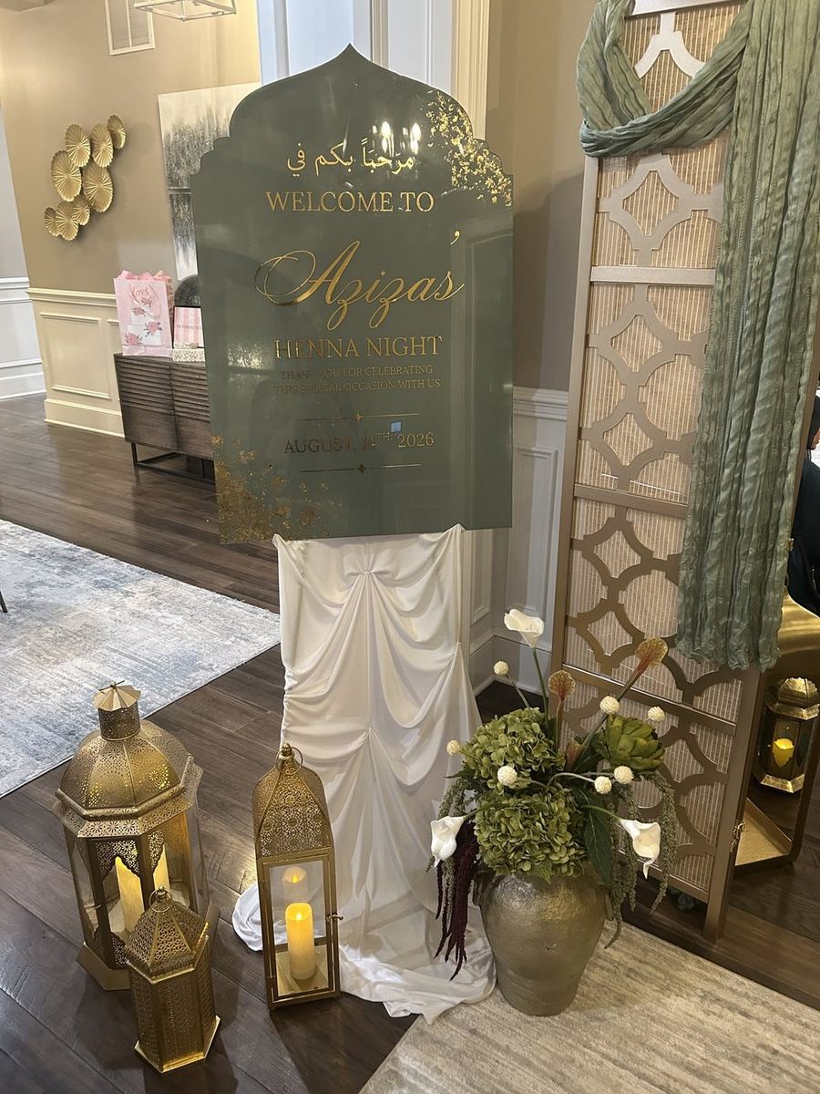 Henna night welcome display with acrylic sign and gold lanterns