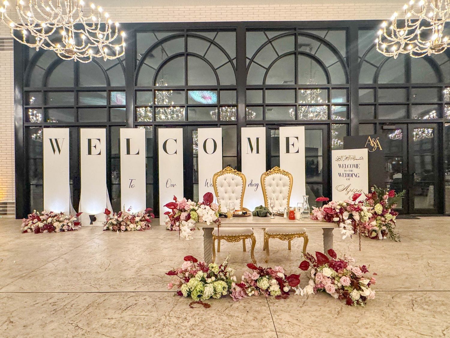 Wedding reception backdrop with WELCOME letters, florals and sweetheart table